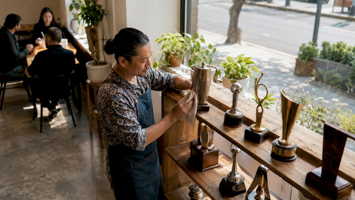 Barista arranging coffee competition trophies