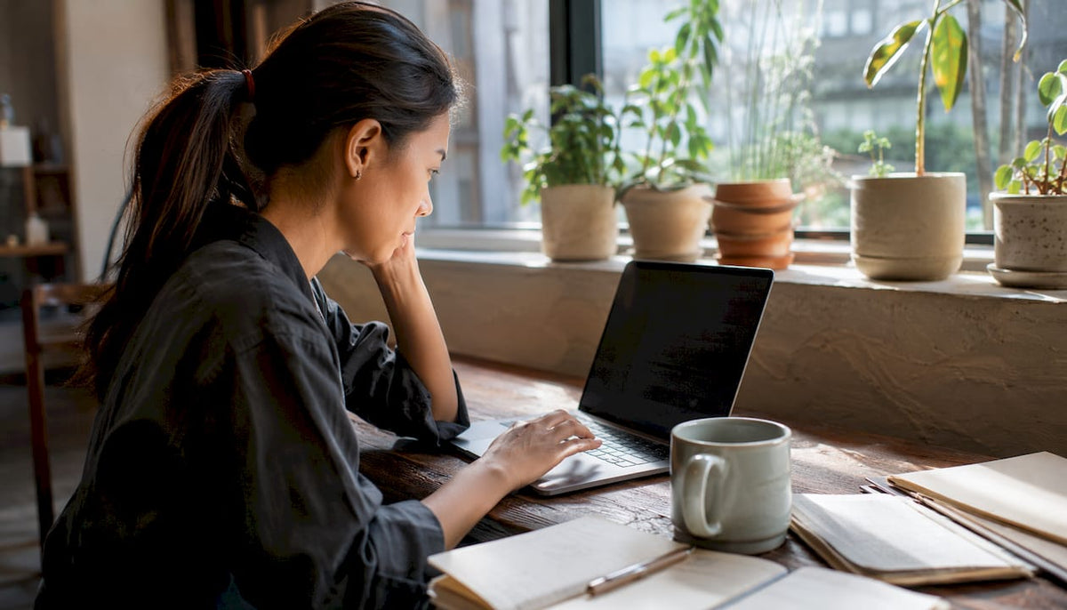 Woman reading business review sites on laptop
